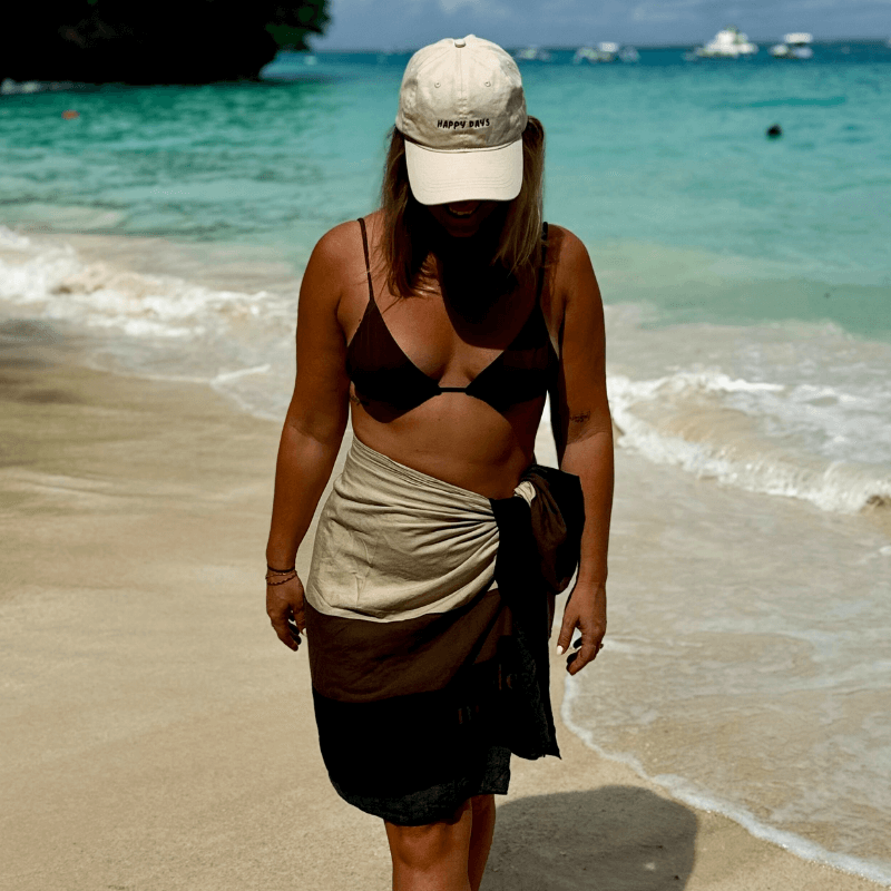 Woman wearing 100% cotton relaxed mid-profile dad cap featuring happy days at the beach Australia