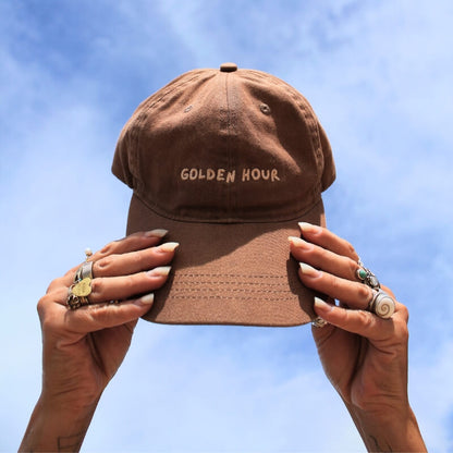 Golden Hour Relaxed Dad Cap Cap Society held in the air