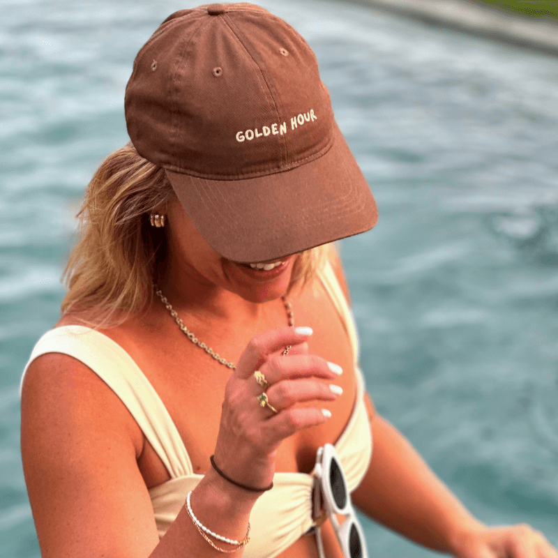 Woman wearing Australian brown mid profile cap with adjustable clasp, relaxed fit, and petite brim