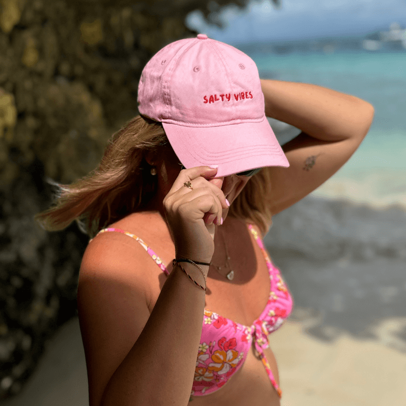 Woman wearing pink salty vibes relaxed cotton mid-profile cap at the beach Australia