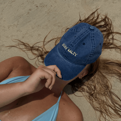 Woman wearing blue cotton Stay Salty washed dad cap from Cap Society Australia at the beach
